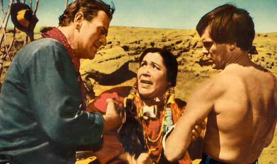 Ethan Edwards (John Wayne) and Martin Pawley (Jeffrey Hunter) interrogate "Look" for the whereabouts of "Scar", the Comanche war chief who holds Debbie (Natalie Wood) captive.